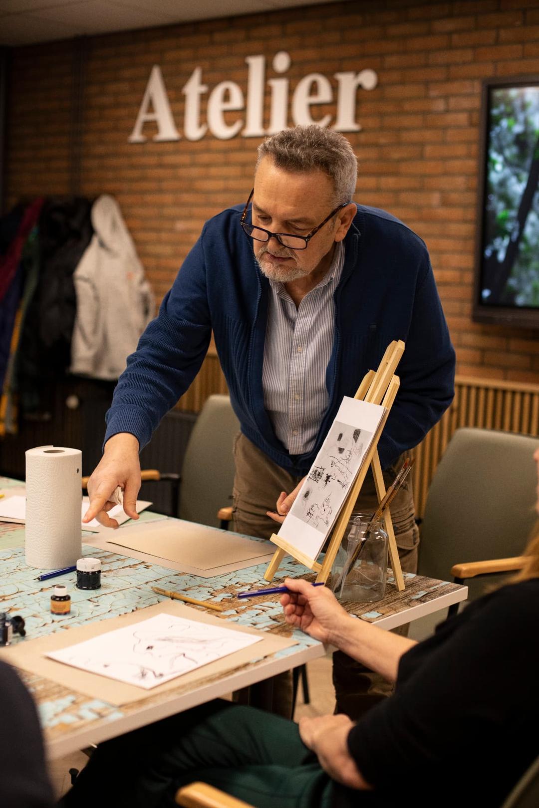 Artist leading a hands-on workshop at a community atelier