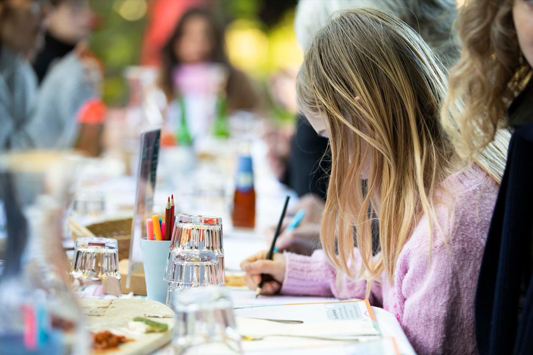 Girl drawing at a long table