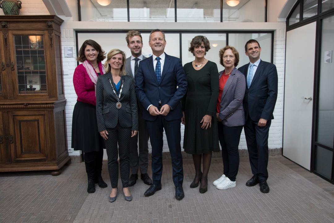 Group portrait of officials and guests indoors