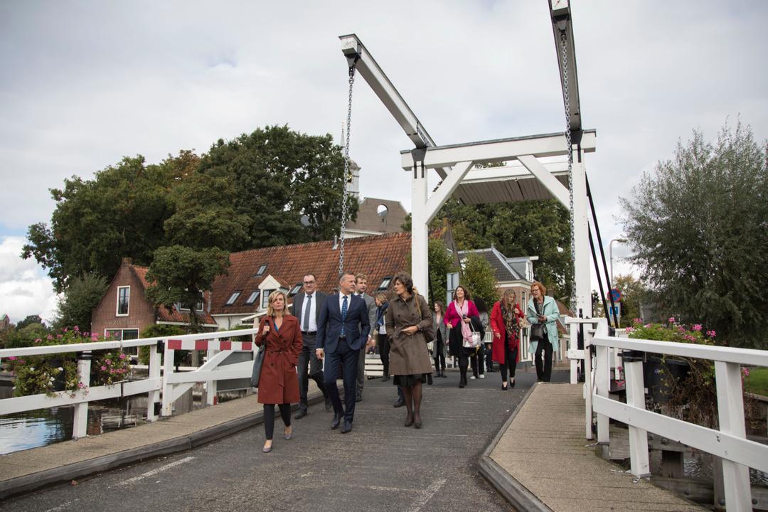Group walking across a white drawbridge in Ouderkerk aan de Amstel