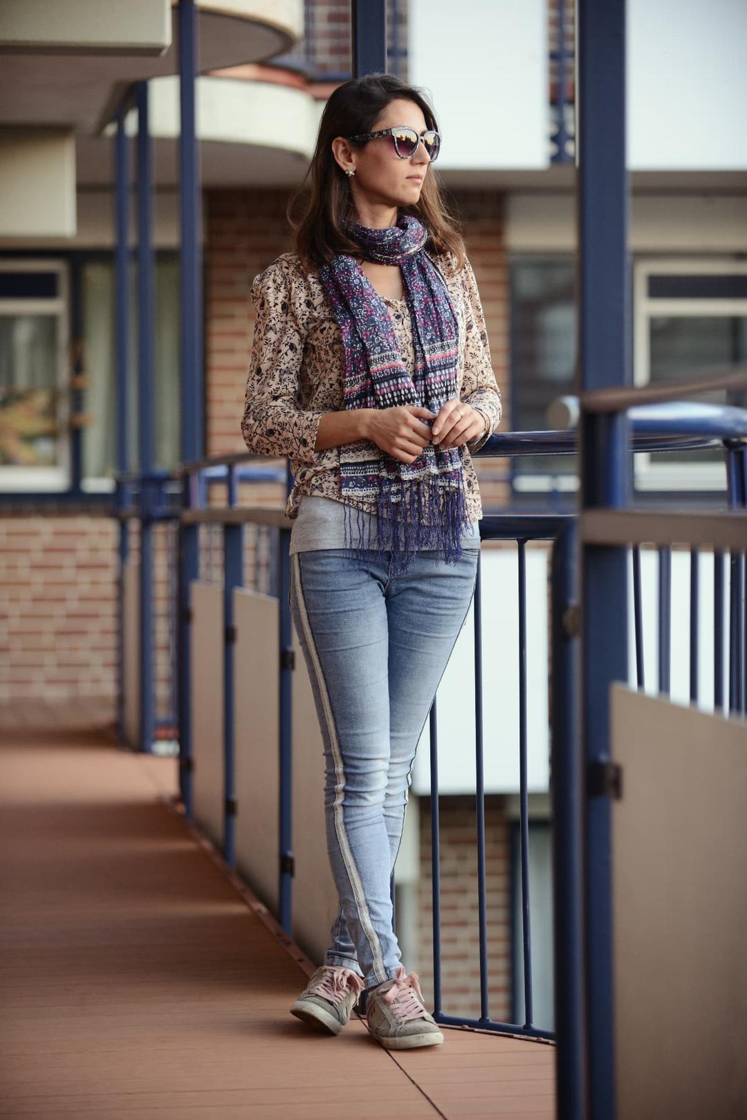 Portrait of Mais Shourbaji standing by a blue railing